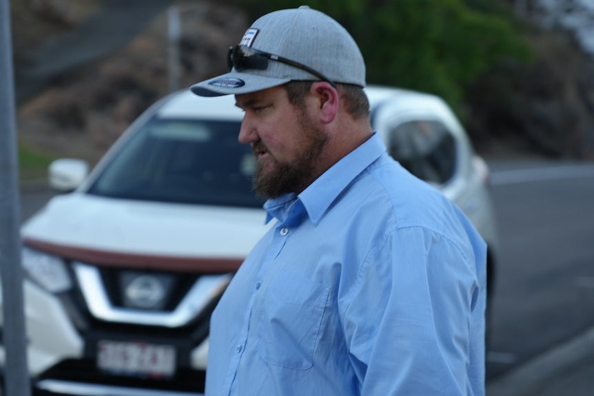 A man in a cap walking away.