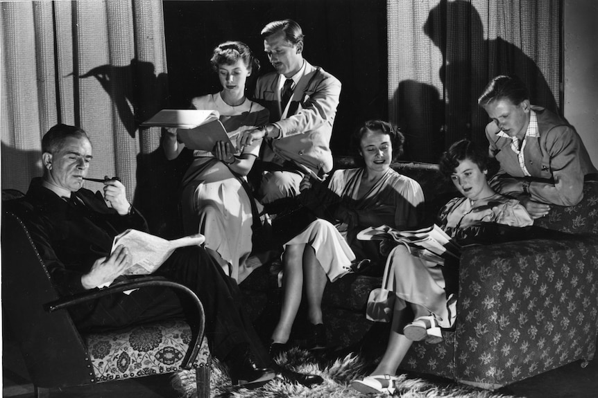 A black and white photo from the 1940s showing a family sitting around a living room 