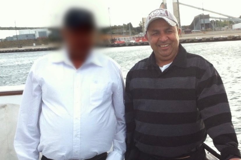 Mr Bhushan pictured on the right, smiling in a striped black and grey jumper.
