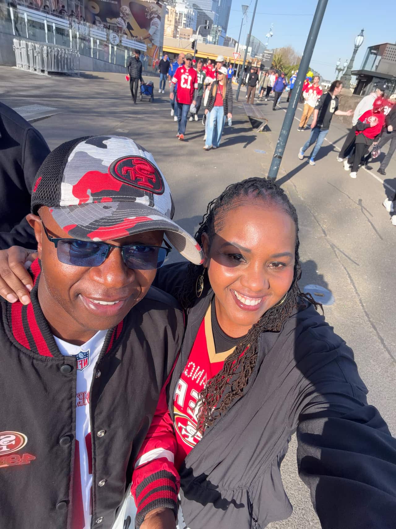 A couple dressed in red smile at the camera for a selfie.