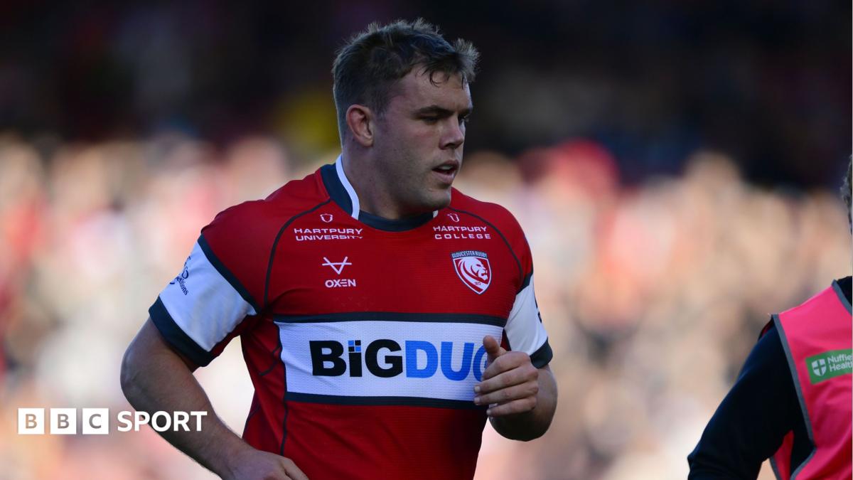 Jack Singleton jogging on the pitch during a match, he is wearing red Gloucester rugby kit