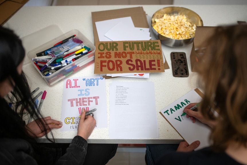Close-up angle of colourful hand drawn posters protesting AI data centres and AI in general.