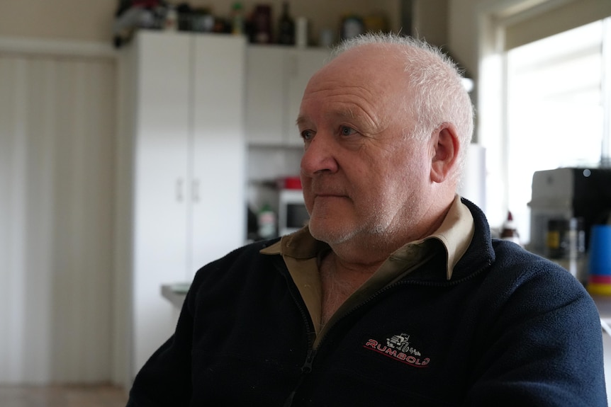 A man sitting at a kitchen table looking away