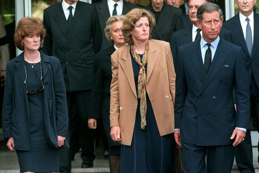 Diana's sisters Sarah McCorquodale and Jane Fellows walk with Prince Charles, with a group of formally-dress people behind them