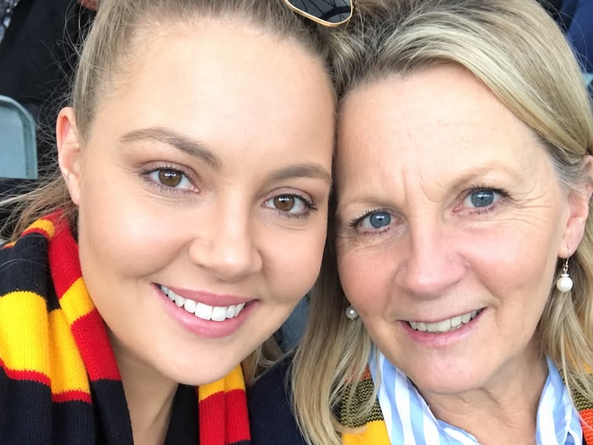 Two women wearing Adelaide Crows scarves
