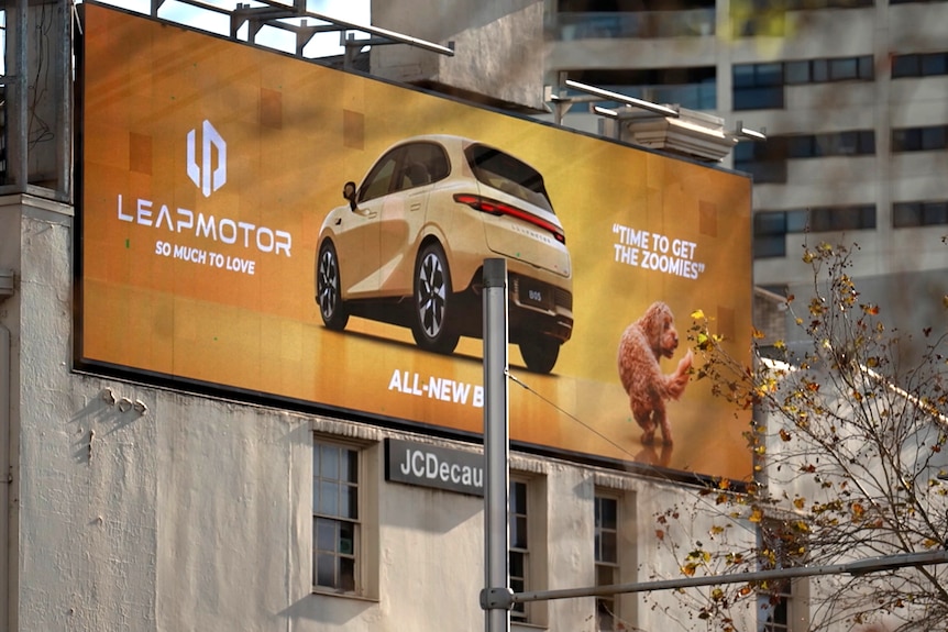 A billboard on the side of a building. It shows a car, and says the brand Leapmotor.