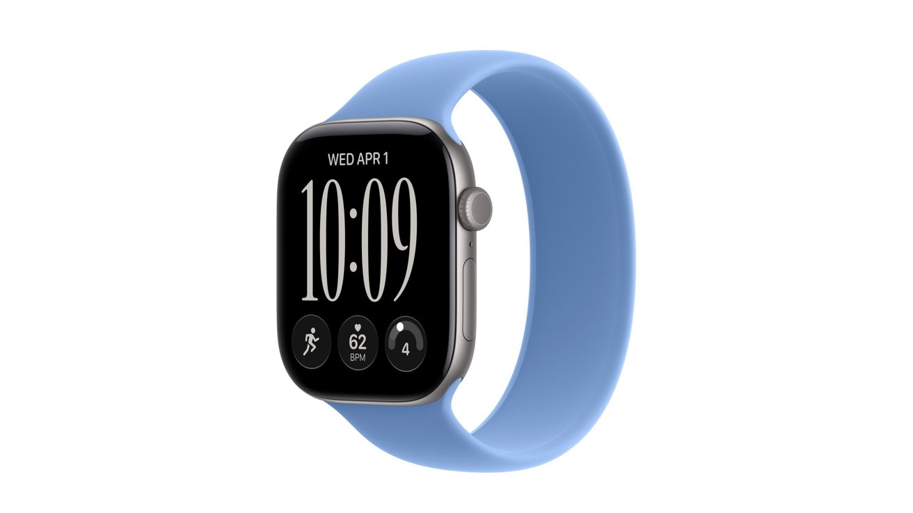 Smartwatch with rectangular black screen, silver edges, and light blue sport band, showing digital time 10:09, date Wednesday April 1, and small circular fitness and activity icons