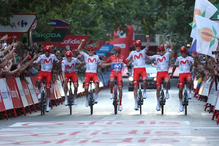 Movistar ride in a line linking arms