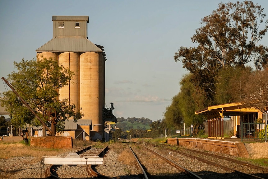 A landscape image of Coolamon train station with fields in the distance and silos across from station