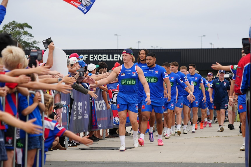a rugby league team hi-fiving fans