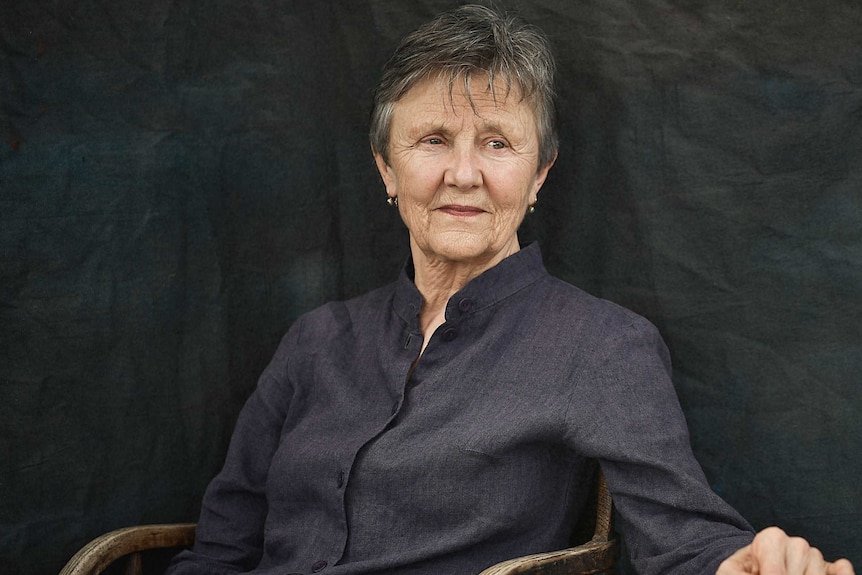 Author photo, Helen Garner seated in a wooden chair