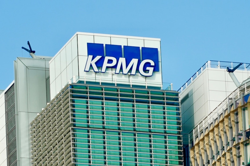 A logo on top of a building with white letters that read KPMG with a blue background.