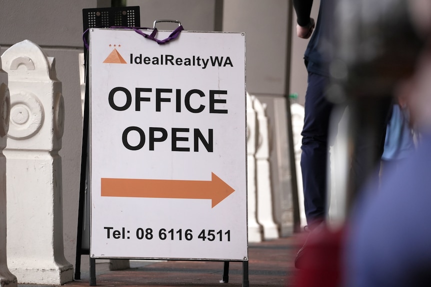 A sign pointing to a real estate agency shop
