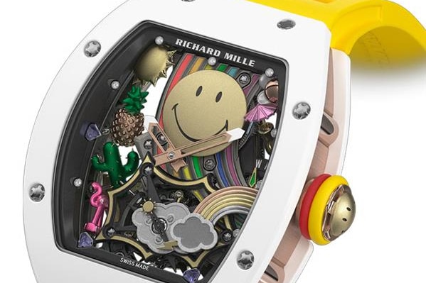 A watch with a yellow band and a colourful face with a smiley face in it.