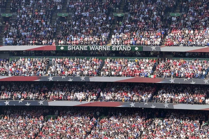 The Shane Warne Stand sign surrounded by USA flags on ad boards