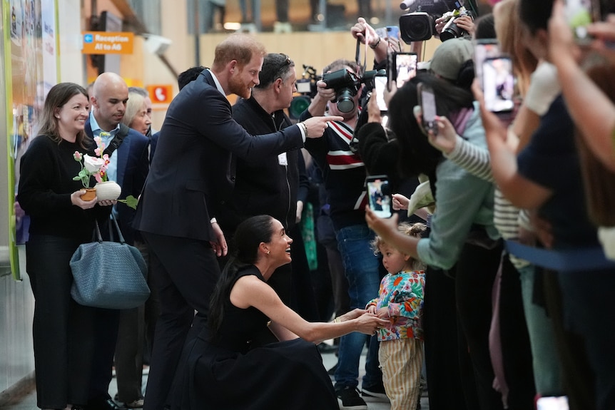 Prince Harry and Meghan Markle meet with members of the public.
