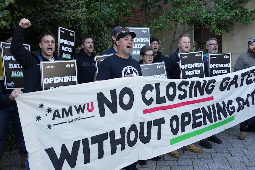 A group of picketing protestors holding signs