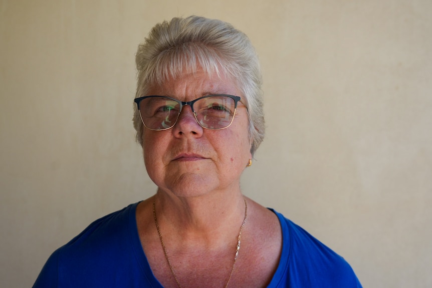 A woman looks directly at the camera.