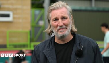 Robbie Savage wearing a black jacket and black top