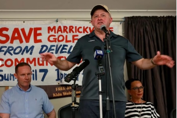 Anthony Albanese stands in front of a microphone at a rally