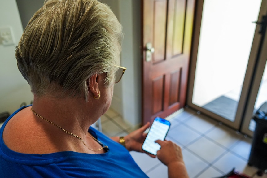 Looking over the shoulder of a woman as she scrolls her phone
