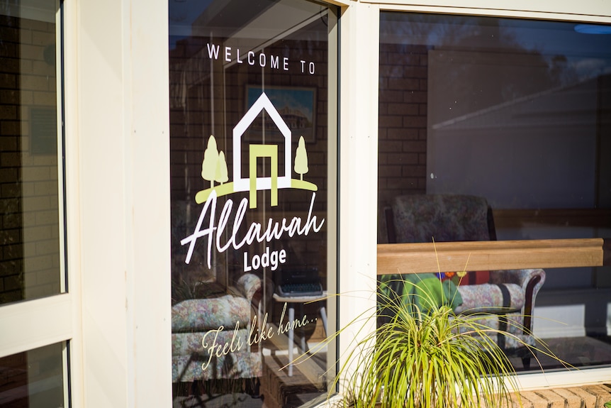 Outside residential facility, signage in window says 'Welcome to Allawah Lodge. Feels like home"