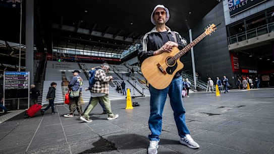 Busker Max Robinson at the foot of the Southern Cross Station staircase, where he performed for, and with, thousands of Oasis fans.
