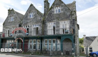 A run down hotel with barriers outside it with the Ellangowan Hotel sign above the door.