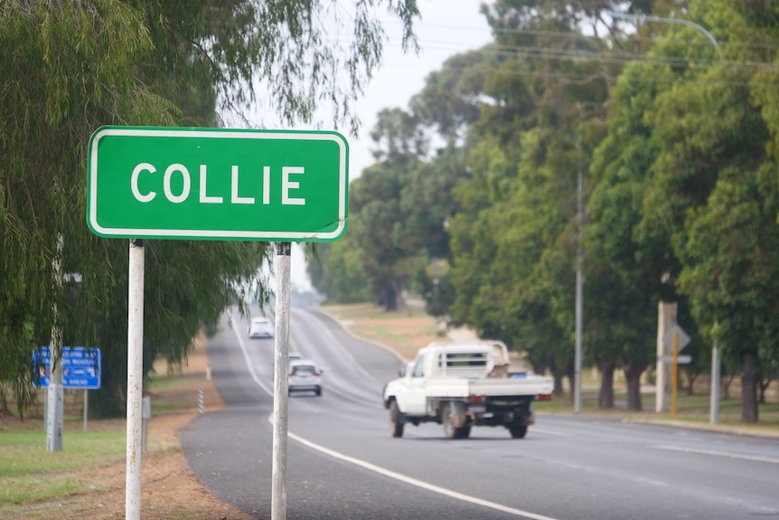 A sign that says "Collie" on the side of a country highway.