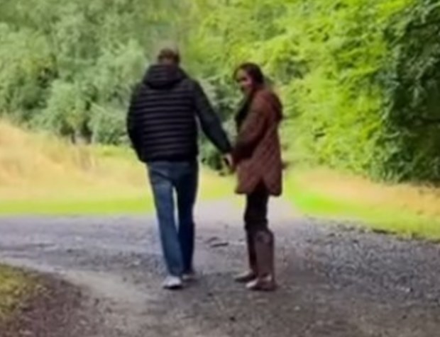 Prince Harry and Meghan are seen in the clip walking and holding hands.