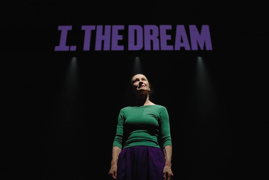 A woman on stage with the words 'I. The Dream' above her.