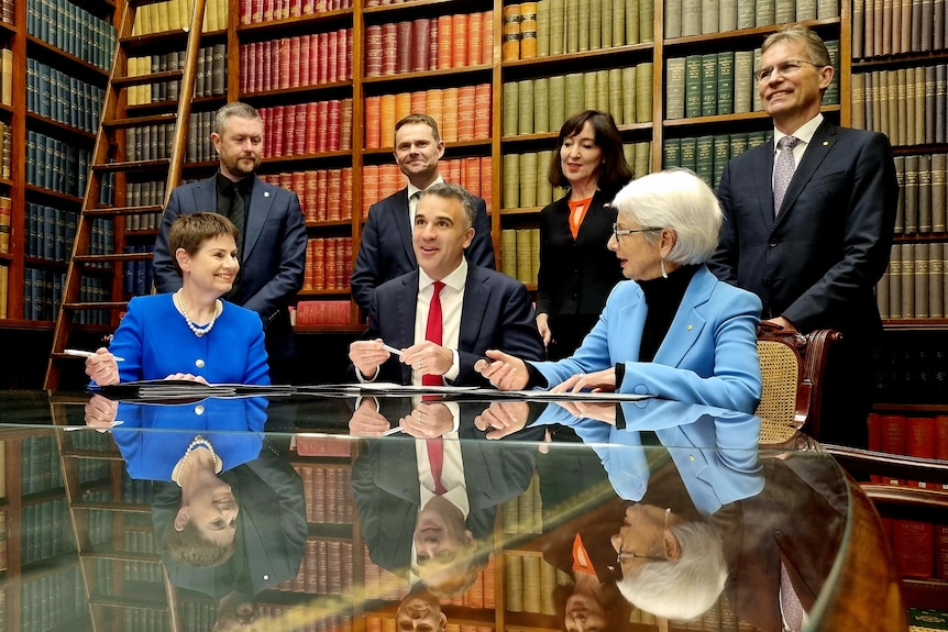 People sign an agreement.