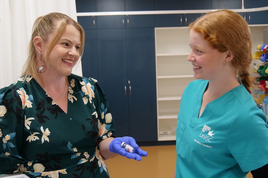 One woman is teaching another woman about the contents of the bottle.