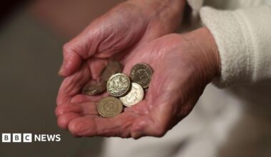 Close up of elderly person with wrinkled hands holding pound coins