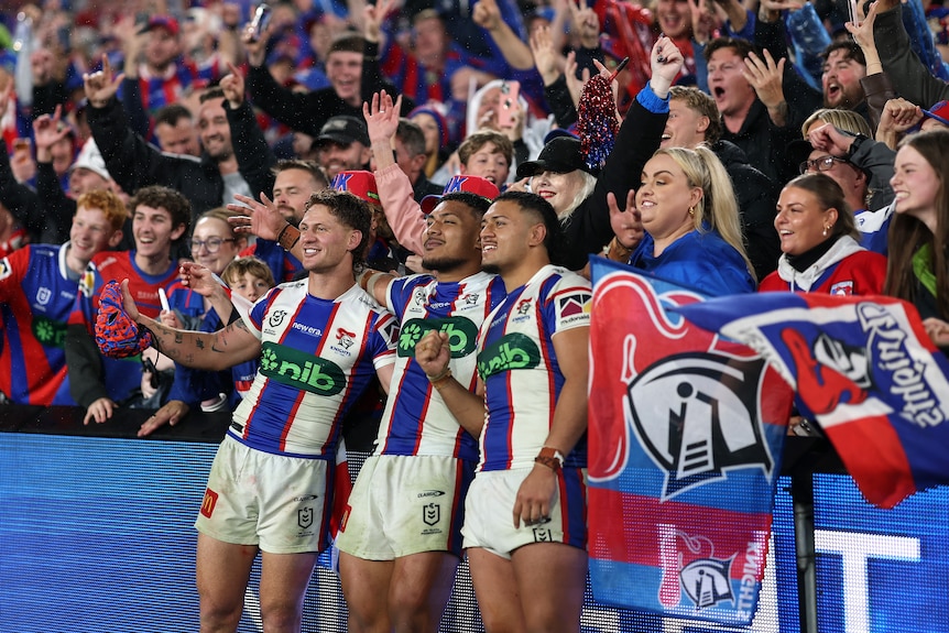 Three NRL players celebrate winning an NRL final