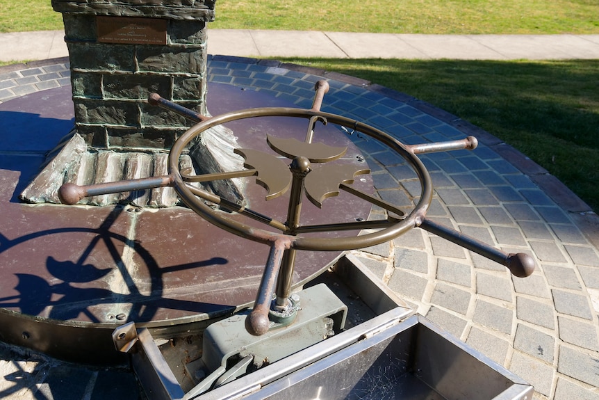 A bronze turntable wheel depicting Mary Poppins umbrellas.