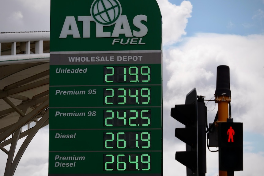 A list of petrol prices, with unleaded being almost $2.20 per litre, next to traffic lights.