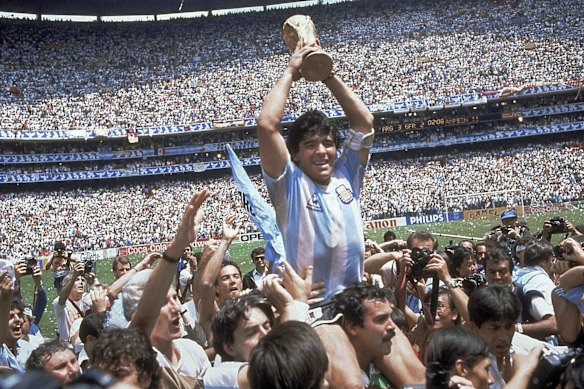 Diego Maradona holds up his team’s trophy after Argentina’s 3-2 victory over West Germany at the World Cup final soccer match at Atzeca Stadium in Mexico City 1986.