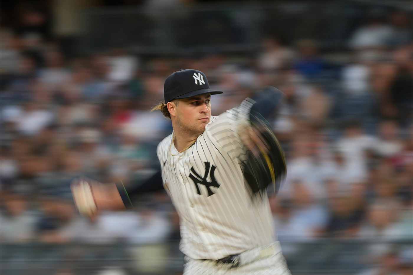 Cam Schlittler shown in the middle of a pitching wind-up, about to release the ball, on the mound.
