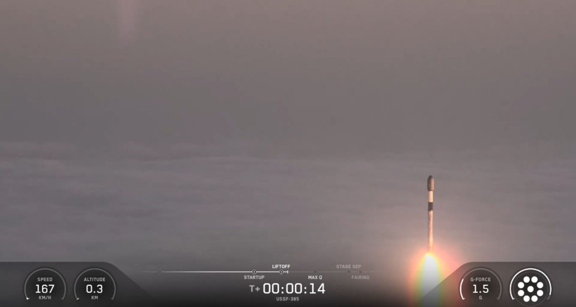 A SpaceX rocket rises out of the clouds and fog during a classified launch to space.