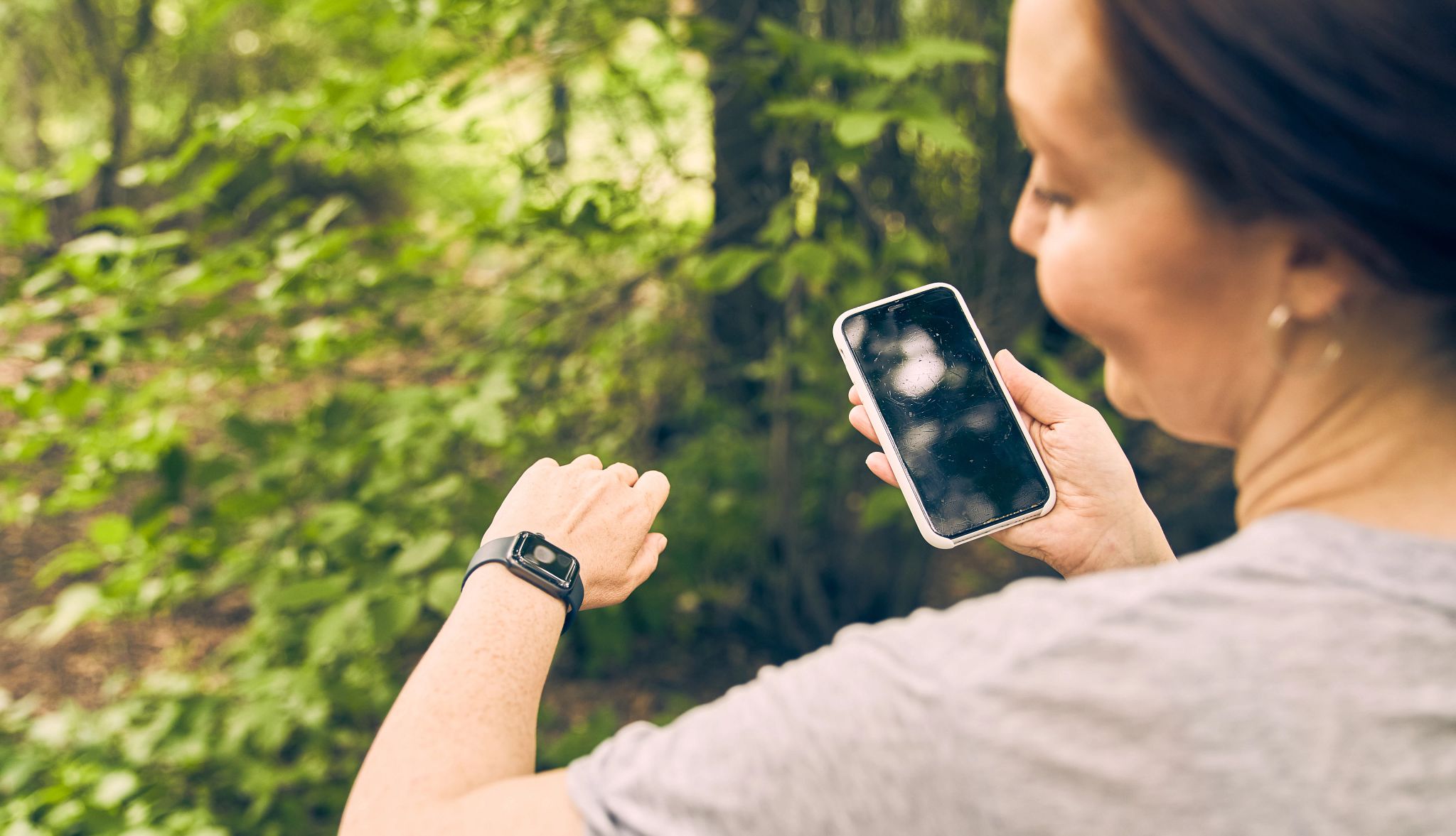 AARP Smart Guide to Wearable Technology a woman looking at her smart watch and her smart phone