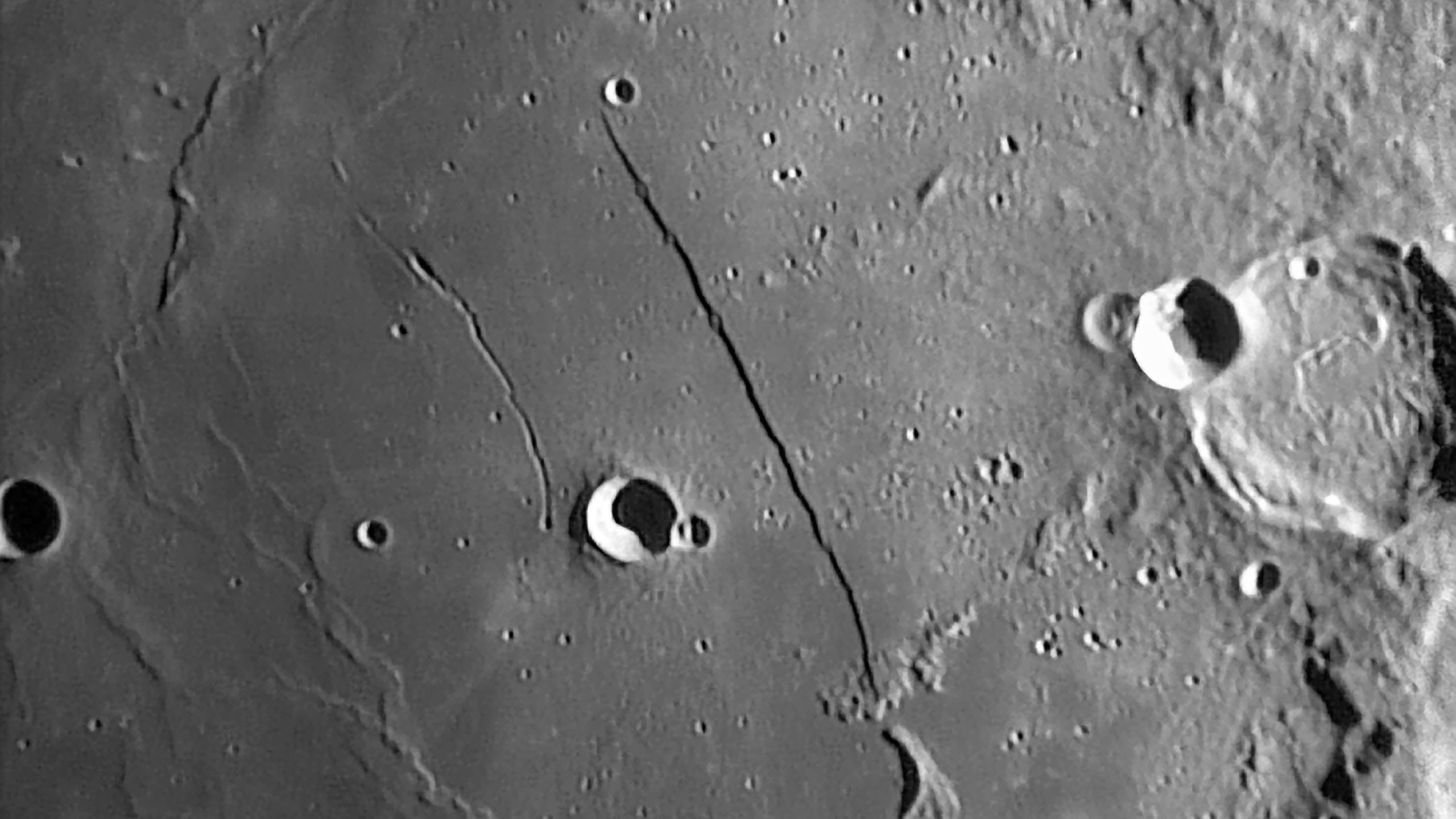 A photo of the moon's surface showing the shadow cast by the Rupes Recta lunar rille.