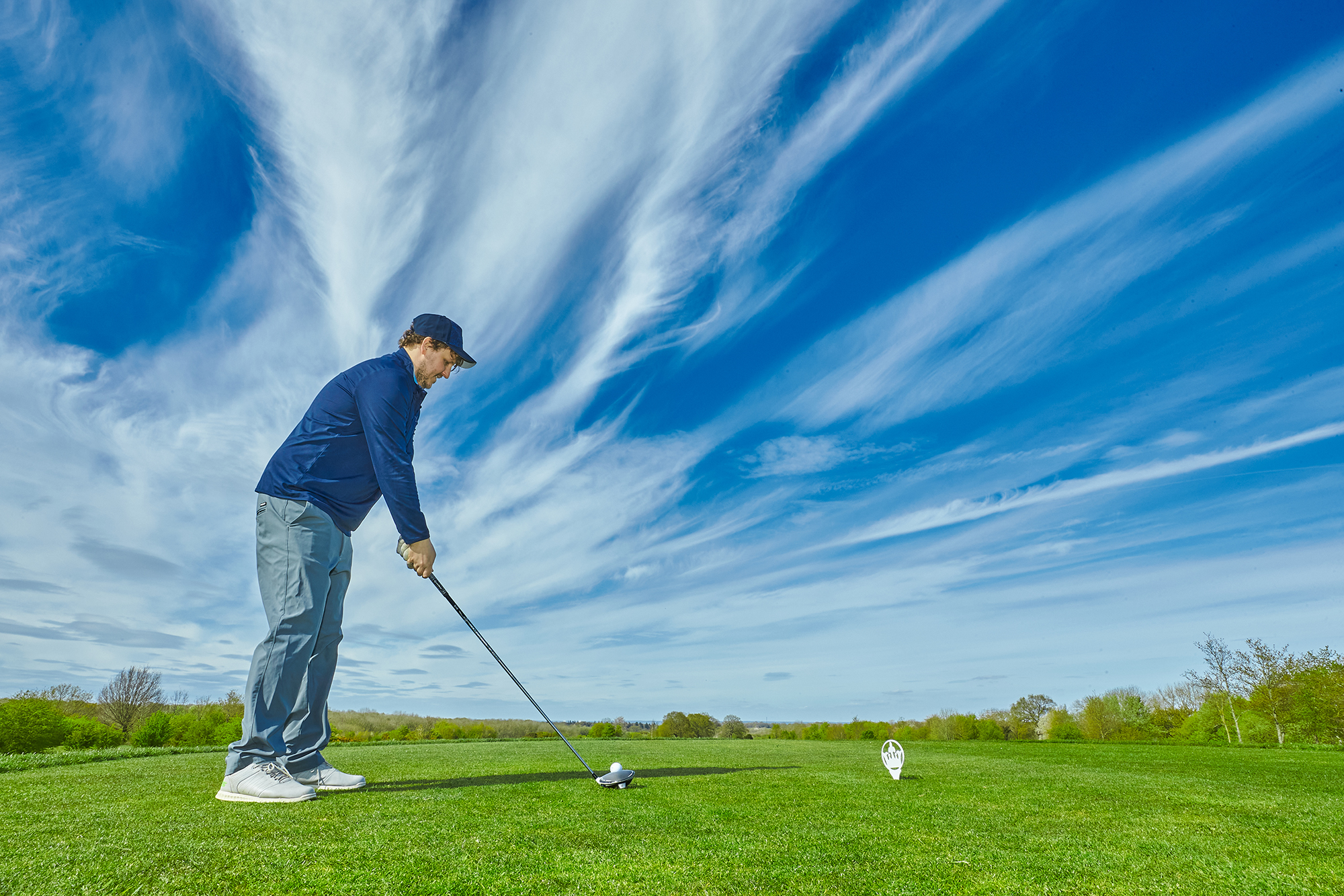 A golfer who has returned to the tee box after losing his first ball and not hitting a provisional, preparing to hit a second shot