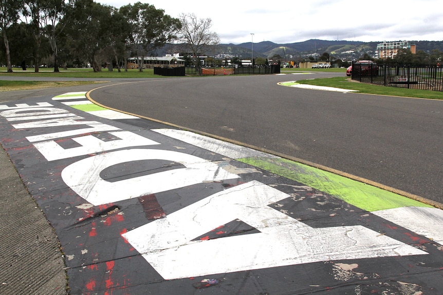 A big kerb with Adelaide written on it and hills in the background