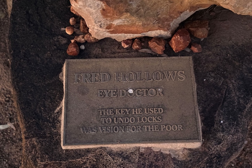 A plaque on a stone saying 'Fred Hollows, eye doctor, the key he used to undo locks was vision for the poor'.