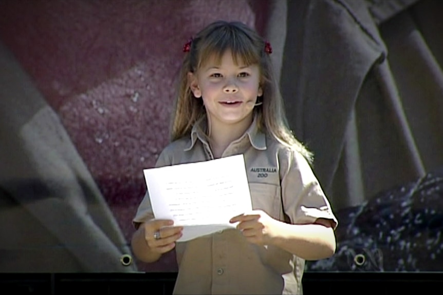 Bindi Irwin reads from a sheet of paper.