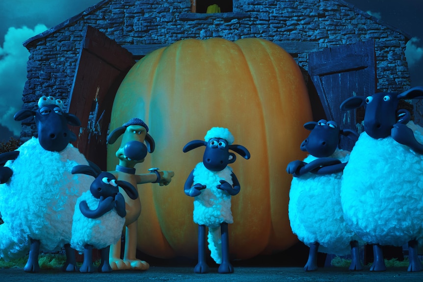 A screenshot of claymation sheep and a massive pumpkin in a barn