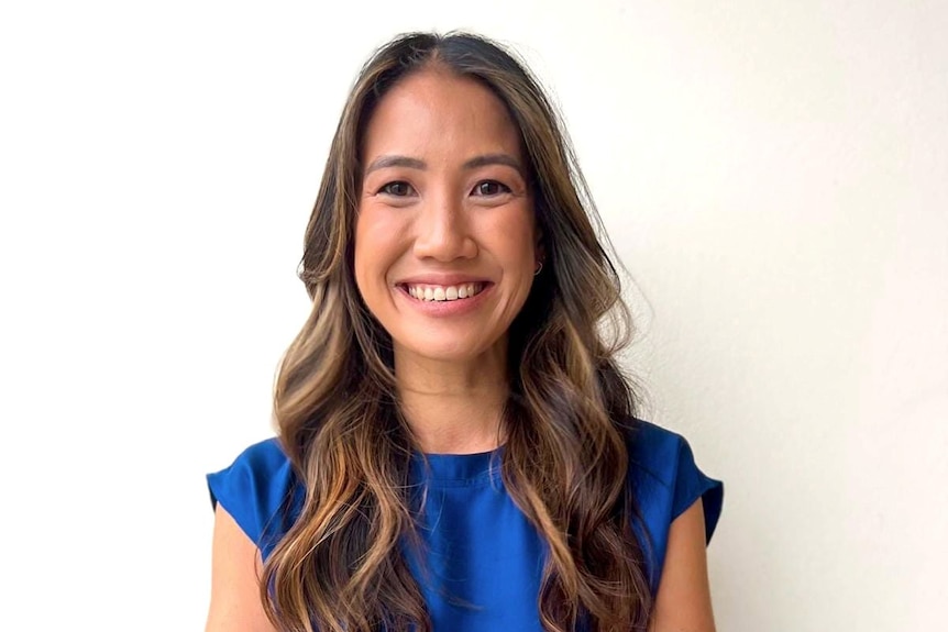 A smiling woman with long brown hair looking directly at the camera.