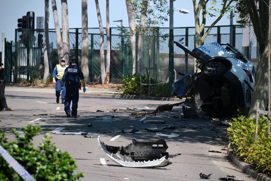 police officers near a turned over police car that crashed killing a young police officer