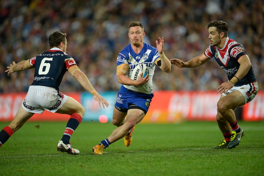 A man runs the ball during a rugby league match 